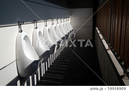 Art light and shadow of men's restroom with white porcelain urinals in line. Modern clean public toilets with tiles.  59938909