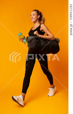 Young Lady Carrying Bag With Mat Going To Gym, Studio Young Lady Carrying Bag With Mat Going To Gym, Studio 59941192