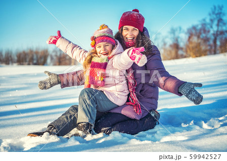 Active mother and daughter playing in winter park 59942527