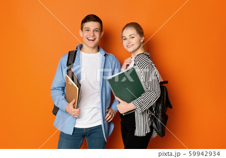 Excited student couple with backpacks and books 59942934