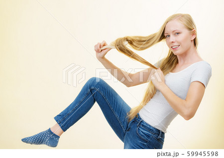 Blonde girl brushing her long hair 59945598