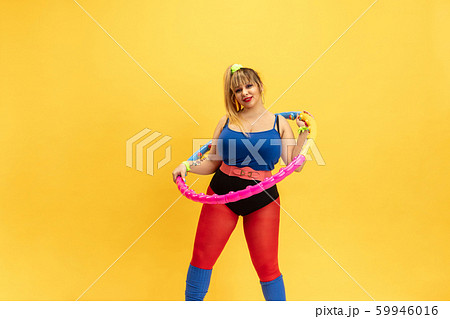 Young caucasian plus size female model's training on yellow background 59946016