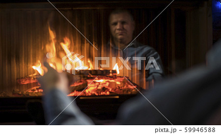 A man with a glass of spirits sits by the fireplace A man with a glass of spirits sits by the fireplace 59946588