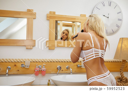 pretty woman dries her hair while looking at her pretty woman dries her hair while looking at her 59952523