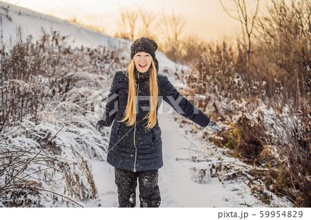 winter girl throwing snowball at camera smiling happy having fun outdoors on snowing winter day winter girl throwing snowball at camera smiling happy having fun outdoors on snowing winter day 59954829