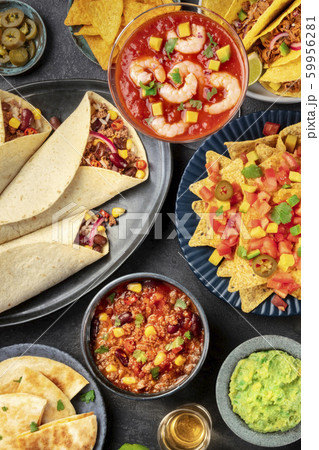 Mexican food, many dishes of the cuisine of Mexico, flatlay, top-down shot on a black background. Shrimp cocktail, nachos, guacamole, burritos, chili con carne Mexican food, many dishes of the cuisine of Mexico, flatlay, top-down shot on a black background. Shrimp cocktail, nachos, guacamole, burritos, chili con carne 59956281