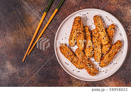 Fried tempeh  with sesame seeds. 59958022