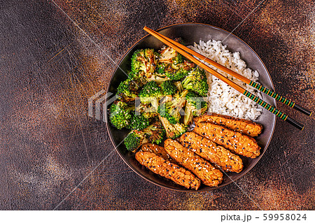Fried tempeh with rice and broccoli. 59958024