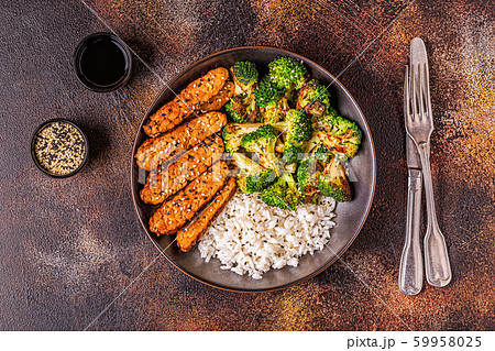 Fried tempeh with rice and broccoli. 59958025