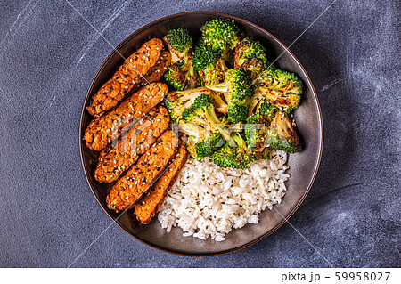 Fried tempeh with rice and broccoli. 59958027