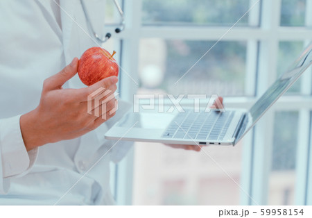 Doctors or nutritionists hold apples and laptops Doctors or nutritionists hold apples and laptops 59958154