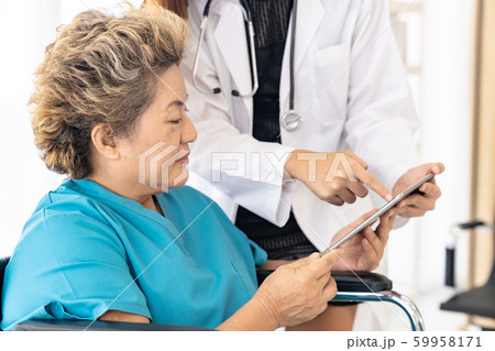 Doctor using tablet with old patient 59958171