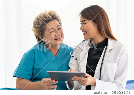Doctor using tablet with old patient 59958172