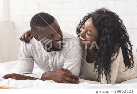 Romantic african american couple cuddling on bed at home 59962623