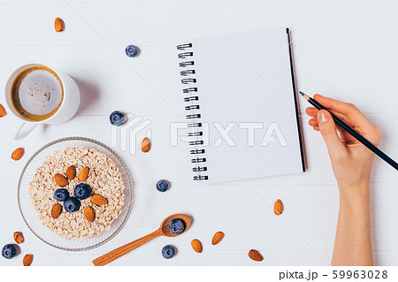 Female hand writing in blank notebook Female hand writing in blank notebook 59963028
