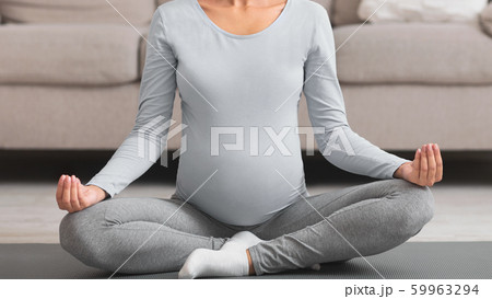 Cropped image of pregnant woman with crossed legs 59963294