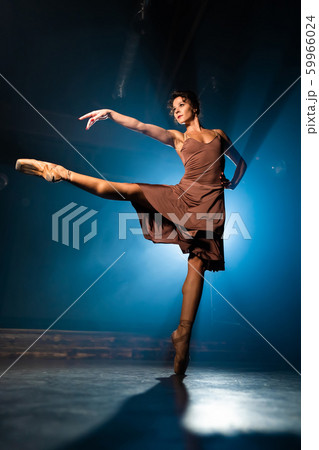 Graceful ballerina in beige dress dancing elements of classical or modern ballet 59966024