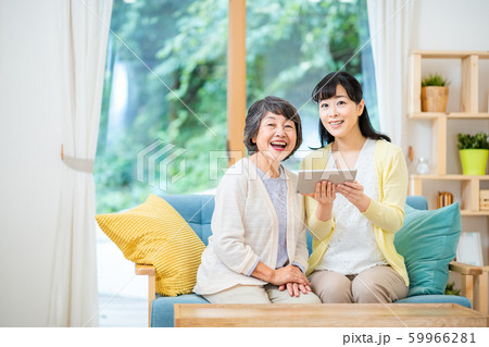 タブレット端末を操作する親子 母子 シニア女性 ミドル女性 2人 タブレット端末を操作する親子 母子 シニア女性 ミドル女性 2人 59966281