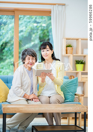 タブレット端末を操作する親子 母子 シニア女性 ミドル女性 2人 タブレット端末を操作する親子 母子 シニア女性 ミドル女性 2人 59966286