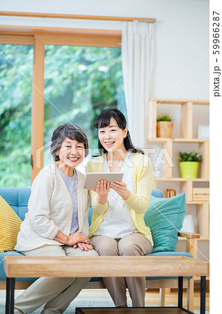 タブレット端末を操作する親子 母子 シニア女性 ミドル女性 2人 タブレット端末を操作する親子 母子 シニア女性 ミドル女性 2人 59966287