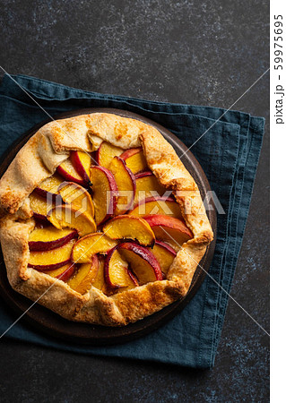 Plate with delicious peach galette on black background. Copy space. Plate with delicious peach galette on black background. Copy space. 59975695