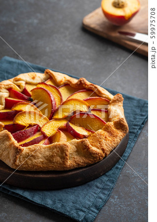 Plate with delicious peach galette on black background. Copy space. 59975708