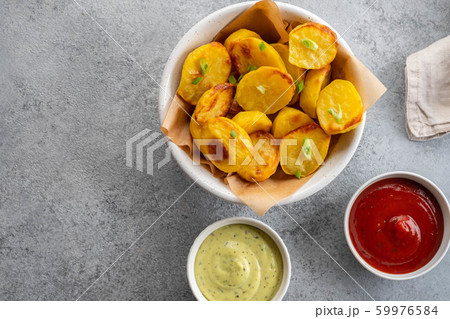Baked potato wedges with cheese and herbs and tomato sauce on grey background - homemade organic vegetable vegan vegetarian potato wedges snack food meal. 59976584