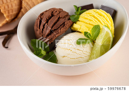 Trio of tasty chocolate vanilla and lime flavored frozen dessert in a white bowl. 59976678