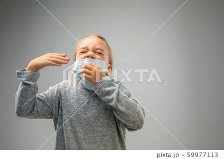 Caucasian girl wearing the respiratory protection mask against air pollution and dusk on grey studio background Caucasian girl wearing the respiratory protection mask against air pollution and dusk on grey studio background 59977113