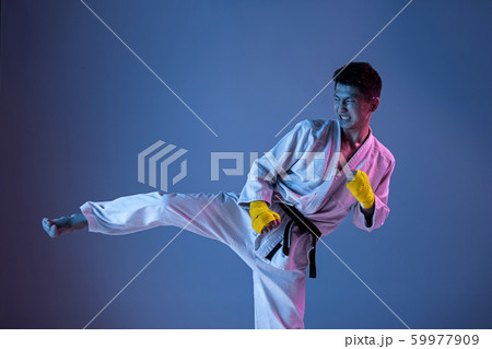 Confident korean man in kimono practicing hand-to-hand combat, martial arts 59977909