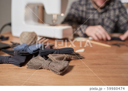 Bow ties made of wool on oak wooden table, adds a finished product. Small craft production 59980474