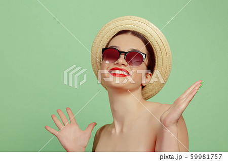 Portrait of beautiful young woman with bright make-up isolated on green studio background 59981757