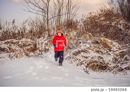 Cute boy in red winter clothes runs fun in the snow. Winter Fun Outdoor Concepts Cute boy in red winter clothes runs fun in the snow. Winter Fun Outdoor Concepts 59983068