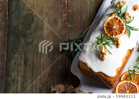 Fruit cake dusted with icing, nuts, kernels pomegranate and dry orange close-up. Christmas and Winter Holidays homemade cake Fruit cake dusted with icing, nuts, kernels pomegranate and dry orange close-up. Christmas and Winter Holidays homemade cake 59983113