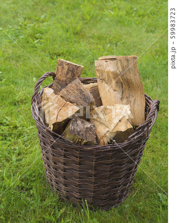 wicker basket full of chopped wood on green grass wicker basket full of chopped wood on green grass 59983723