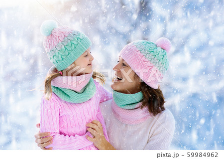 Mother and child in knitted winter hats in snow. Mother and child in knitted winter hats in snow. 59984962