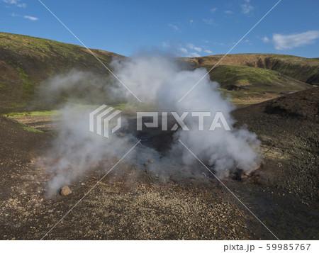Hot spring with boiling water rising from rocks in 59985767