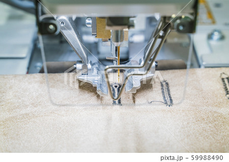 Modern overlock sewing machine handle loops on the leather coat. Horizontal image, close up Modern overlock sewing machine handle loops on the leather coat. Horizontal image, close up 59988490