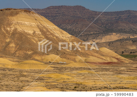 Cars in the distance crossing the deserted, wavy and colorful landscape of Painted Hills Cars in the distance crossing the deserted, wavy and colorful landscape of Painted Hills 59990483