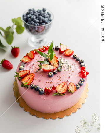 Homemade pink birthday cake decorated with berries: strawberries, blueberries, red currant and flowers. Food concept. Girl birthday or wedding cream cheese pink cake on white background Homemade pink birthday cake decorated with berries: strawberries, blueberries, red currant and flowers. Food concept. Girl birthday or wedding cream cheese pink cake on white background 59993849