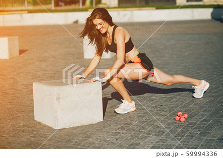Girl is engaged in morning exercise in the park. 59994336