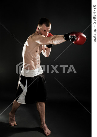 Muscular kickbox or muay thai fighter punching. 59994730
