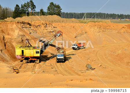 Quarry excavator loading sand into dump truck 59998715