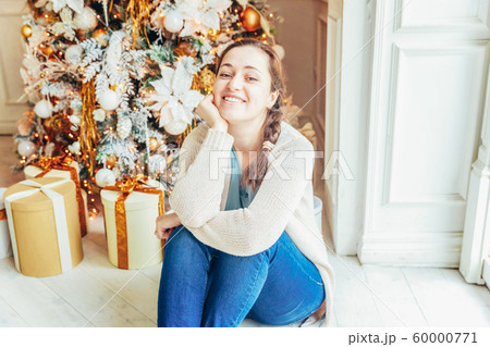 Young girl with gift box near Christmas tree on Young girl with gift box near Christmas tree on 60000771