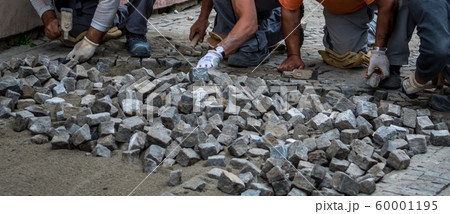 Team Of Construction Workers Building Pavement With Cobblestones Team Of Construction Workers Building Pavement With Cobblestones 60001195