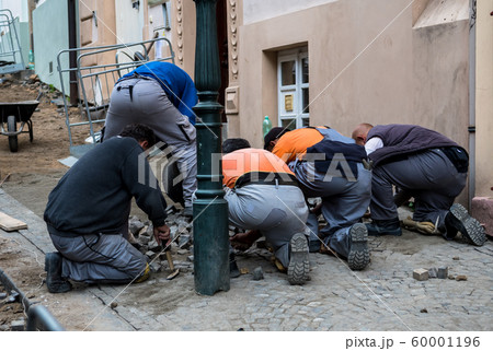 Team Of Construction Workers Building Pavement With Cobblestones 60001196