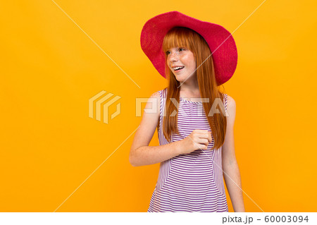 European girl in a red panama on a yellow background 60003094