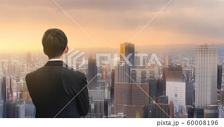 Businessman looking at futuristic city in sunset. Business concept Businessman looking at futuristic city in sunset. Business concept 60008196