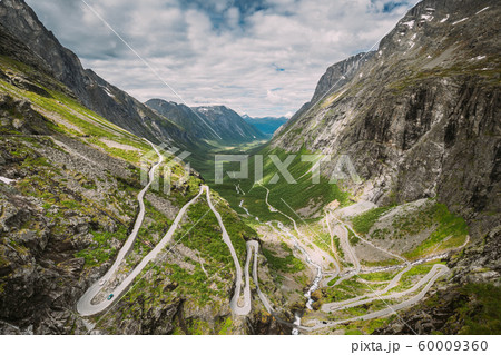 Trollstigen, Andalsnes, Norway. Cars Goes On Serpentine Mountain Road Trollstigen. Famous Norwegian Landmark And Popular Destination. Norwegian County Road 63 In Summer Day 60009360