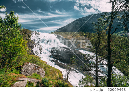 Kinsarvik, Hordaland, Norway. Waterfall Nyastolfossen In Hardangervidda Mountain Plateau. Nyastolsfossen in Spring Sunny Day. Height Of 115 m. Norwegian Landmark And Popular Destination 60009448
